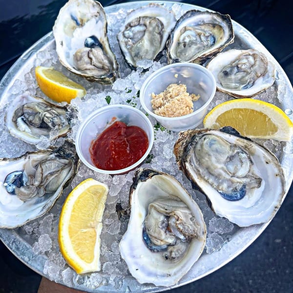 A dozen fresh oysters on the half shell, served on ice with lemon, cocktail sauce, and horseradish.